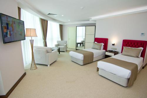 a hotel room with two beds and a flat screen tv at King Sky Tower Hotel in Batumi