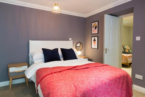 a bedroom with a large bed with a red blanket at Ceres Newly refurbished 3 bedroom in Heart of Bath in Bath