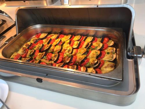 a pan of chicken and vegetables cooking in an oven at Sky Hotel Baku in Baku