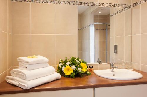 a bathroom with a sink and a bunch of towels at Adair Arms Hotel in Ballymena