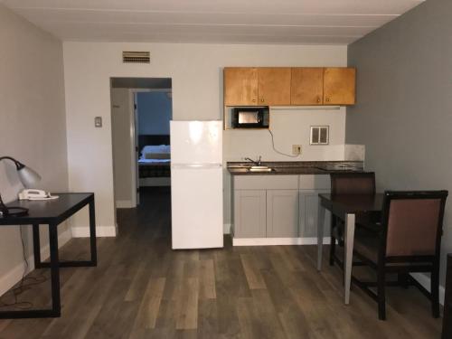 a kitchen with a white refrigerator and a table at Belmont Inn & Suites Virginia Beach in Virginia Beach