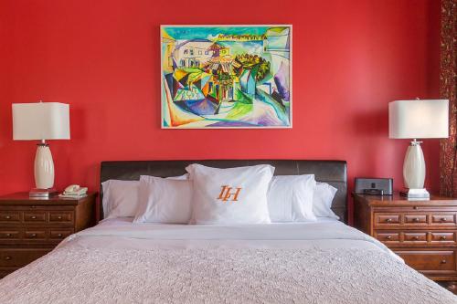 a red bedroom with a bed with two nightstands and two lamps at LHotel in Montreal