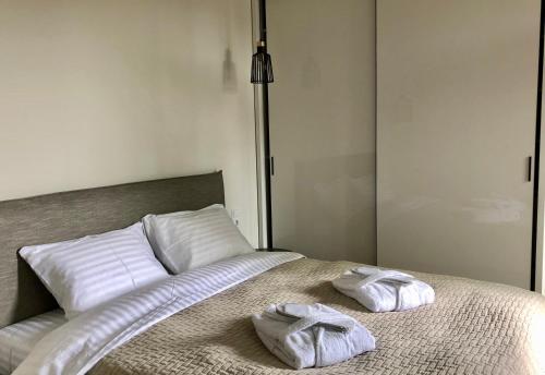 two towels sitting on top of a bed at Memel home old city apartment in Klaipėda