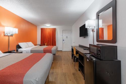 Motel 6-Bryan, TX - University Area في براين: غرفة فندقية بسريرين وتلفزيون بشاشة مسطحة