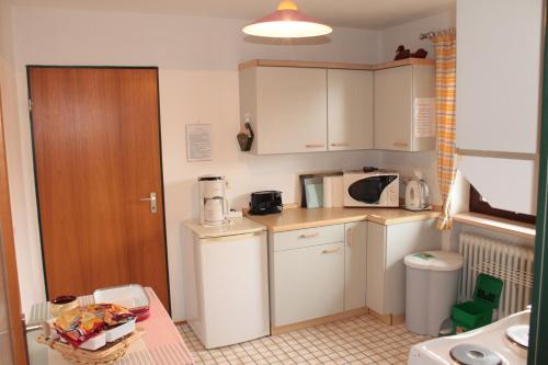 a small kitchen with a white refrigerator and a table at Haus Christine in Halblech