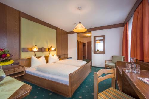 a hotel room with a bed and a desk at Alte Post in Ellmau