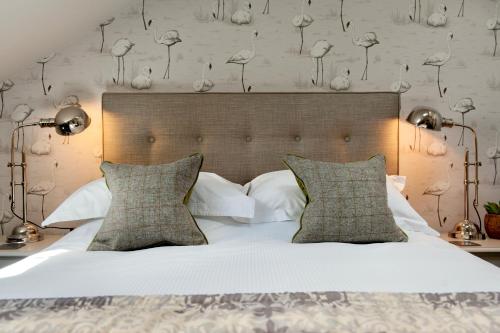 1 dormitorio con 1 cama grande con sábanas y almohadas blancas en The Halston Carlisle en Carlisle