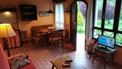 a living room with a television and a table with a television at Apartamentos El Cueto in Oviñana