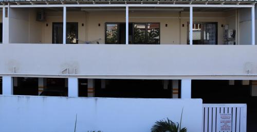 a white building with windows and a white wall at Mahina Luxury 2 Bedroom Apartment with Pool in Flic-en-Flac