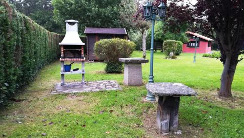 a park with a bird feeder in the grass at Apartamentos El Cueto in Oviñana