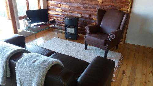 a living room with a couch and a chair at Shepherd Farm in Winterton