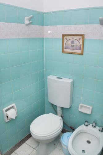 a blue bathroom with a toilet and a sink at Marcopolo Inn Hostel Bariloche in San Carlos de Bariloche