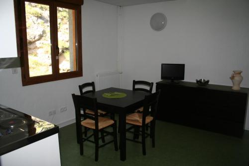 a kitchen with a black table and chairs and a window at Residence Adrechas et Spa in La Colmiane