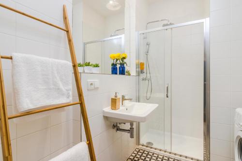 a white bathroom with a shower and a sink at Zizkov APT Prague PARKING by Michal&Friends in Prague