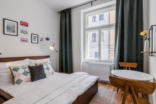 a bedroom with a bed and a window and a table at Zizkov APT Prague PARKING by Michal&Friends in Prague