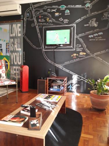 uma sala de estar com uma parede preta com um mapa em Casa Beatles Hostel Bauru em Bauru