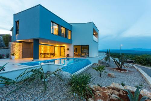 uma casa com uma piscina em frente em Villa Silente em Krk