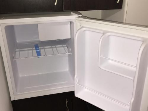 - un réfrigérateur vide avec une porte ouverte dans la cuisine dans l'établissement Simic, à Aranđelovac