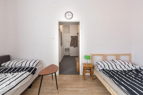 two beds in a room with a clock on the wall at OA - Apartament 50m od Rynku - Old Market Square in Wrocław