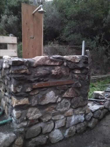 a stone wall with a wooden box on top at Villa Haris in Sarti