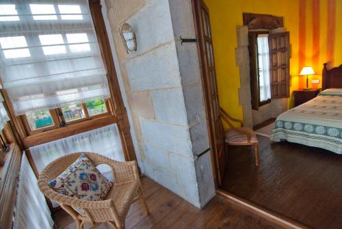 a bedroom with a bed and a table and a mirror at La Casa del Organista in Santillana del Mar