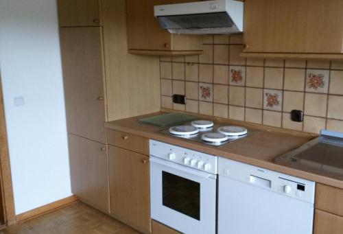 een keuken met een fornuis en een witte oven bij Reiterhof Jägersburg Ferienwohnung in Varel