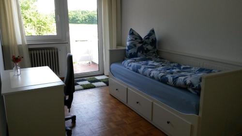 a bedroom with a bed with a desk and a window at Reiterhof Jägersburg Ferienwohnung in Varel
