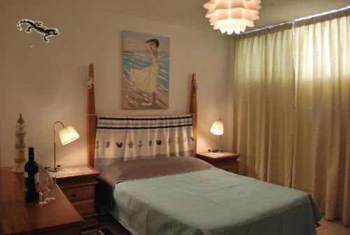 プエルト・デ・サンティアゴにあるLa Arena Beachのベッドルーム1室(ベッド1台、ランプ2つ、窓付)