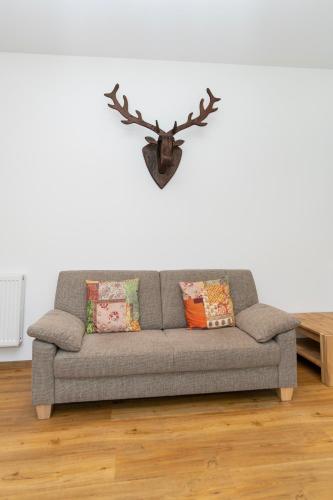 a living room with a couch and antlers on the wall at Old Town Apartments in Kaufbeuren