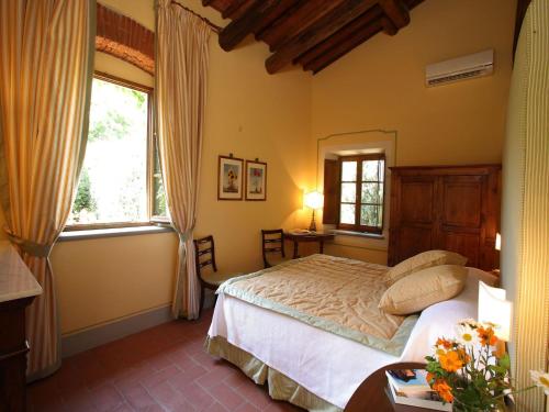 a bedroom with a bed and a large window at Villa Le Barone in Panzano