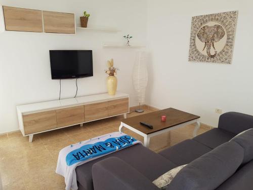 a living room with a couch and a flat screen tv at Casa Aray in Tías