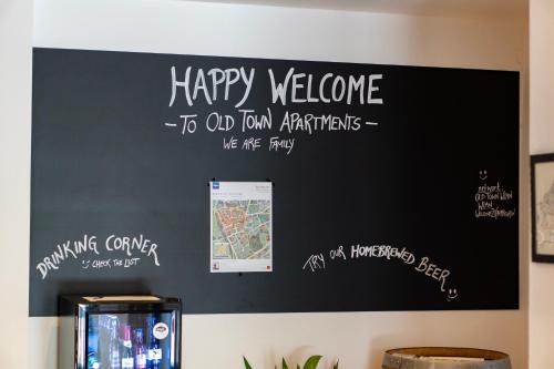 a blackboard with a happy welcome to old town australias at Old Town Apartments in Kaufbeuren