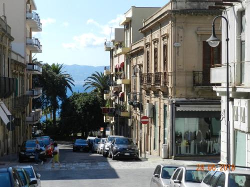 una calle de la ciudad con coches aparcados en la calle en La Casa Di Anna B&B, en Reggio Calabria