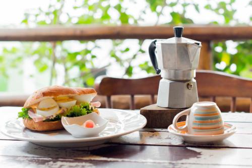 a sandwich on a plate on a table with a coffee maker at Casa de Palos Boutique in Tarapoto