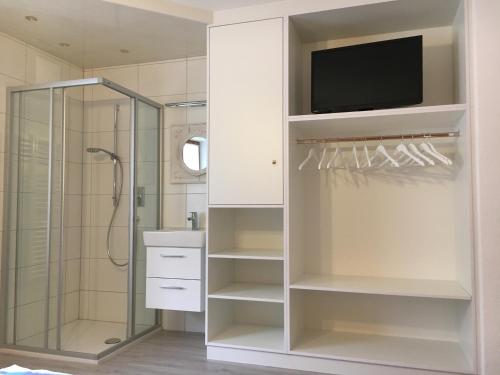 a bathroom with a shower and a tv on a wall at Ferienwohnung Kopp in Aschau