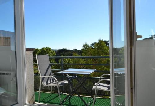 a table and two chairs on a balcony with a view at Le petit studieux - Parking - Animaux acceptés - Centre ville accessible à pied in Albi