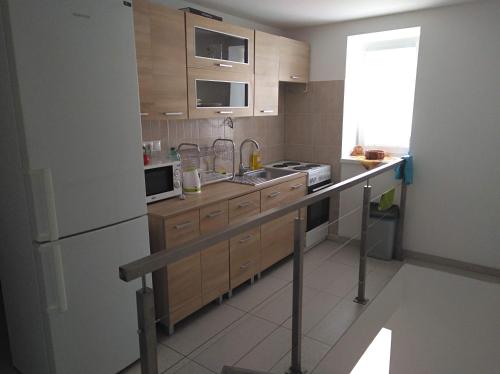a small kitchen with wooden cabinets and a refrigerator at Ubytovanie Janka in Handlová