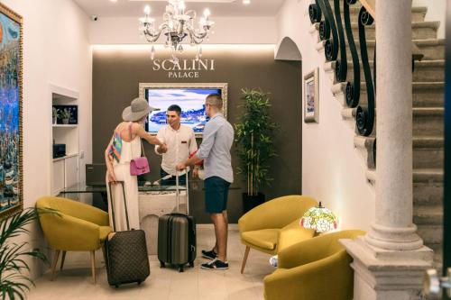 a man and woman standing in a lobby with luggage at Scalini Palace in Dubrovnik