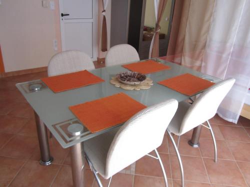 a glass table with white chairs and orange napkins at Apartments Villa Bella Vista Hvar in Hvar