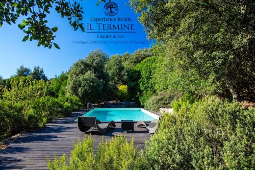 a swimming pool in a garden with trees at Experience Relais " Il Termine Elba " in Rio Marina