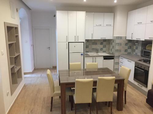 a kitchen with a wooden table and white cabinets at Apartment Bacvice in Split