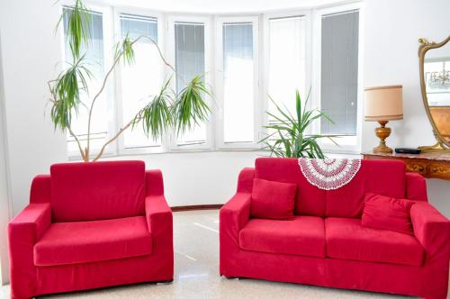 two red chairs and a red couch in a living room at Casa Maddalena in Nocera Umbra