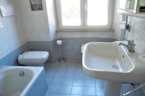 a white bathroom with a sink and a toilet at Casa Maddalena in Nocera Umbra