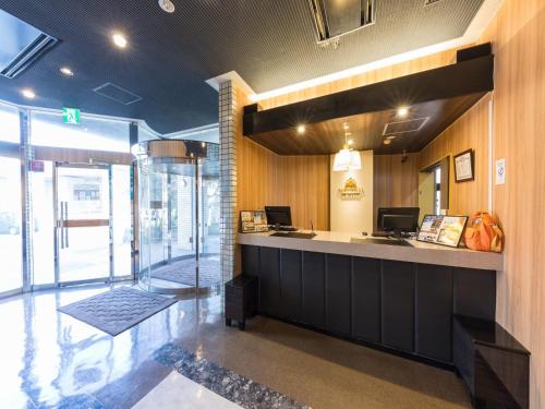 a lobby with a reception counter and a glass door at APA Hotel Tsubame-Sanjo Ekimae in Tsubame