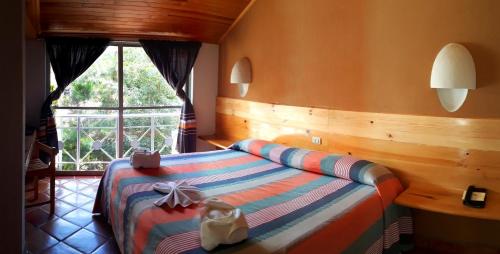 a bedroom with a bed in a room with a window at Axkan Arte Hotel in San Cristóbal de Las Casas