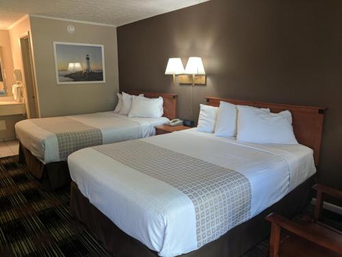 um quarto de hotel com duas camas com almofadas brancas em South Shore Inn em Sandusky