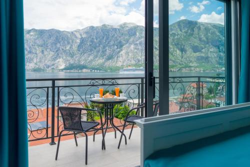 a balcony with a table and chairs and a view of the water at StOliva RESIDENCE with infinity pool in Kotor