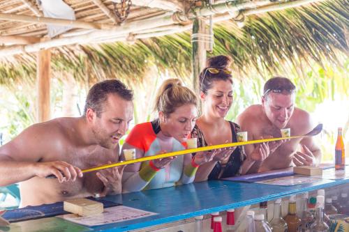 a group of people standing around a table at Ranguana Caye Cabanas in Placencia Village