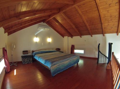 een slaapkamer met een bed in een kamer met houten plafonds bij Casa Nostos in Vasiliki