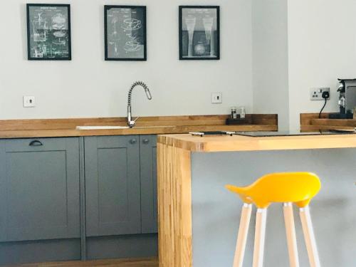 a kitchen with a counter and a yellow stool at Apartment 42a by the River in Inverness